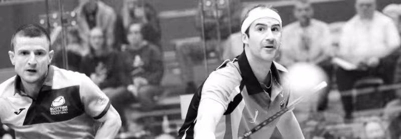 Two squash players focused on the ball.